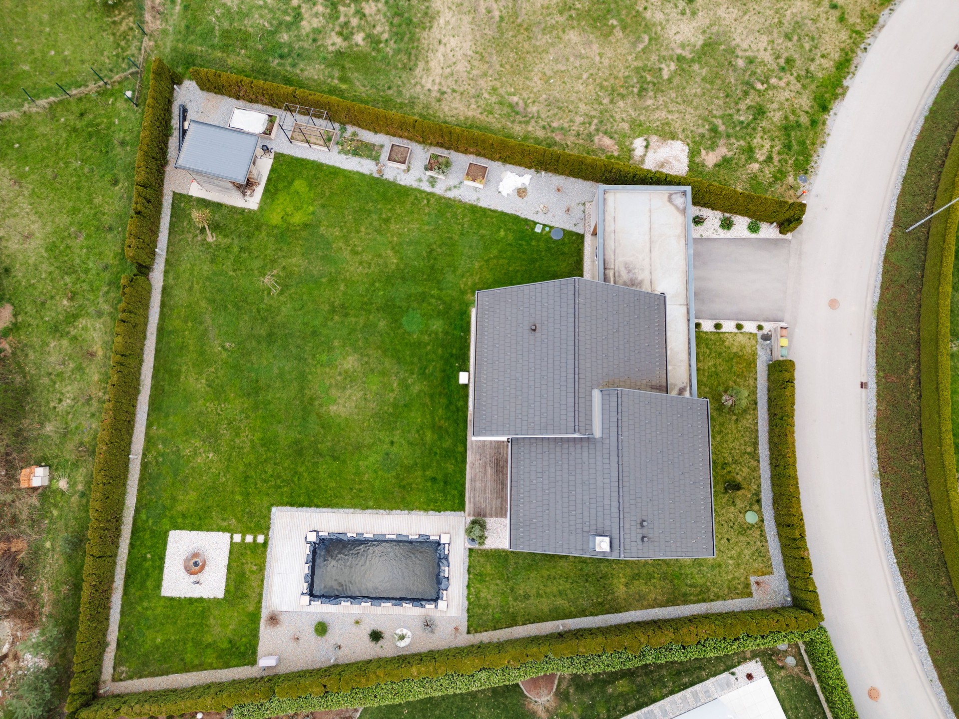 Aerial view of modern house with garden and pond